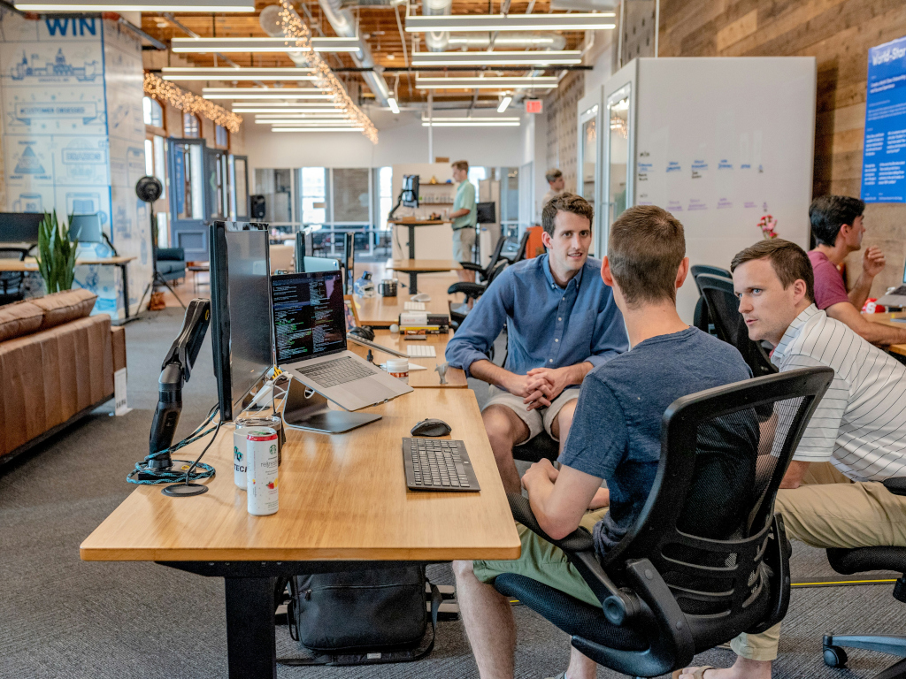 Teamwork in bright office with largely wooden desks and walls